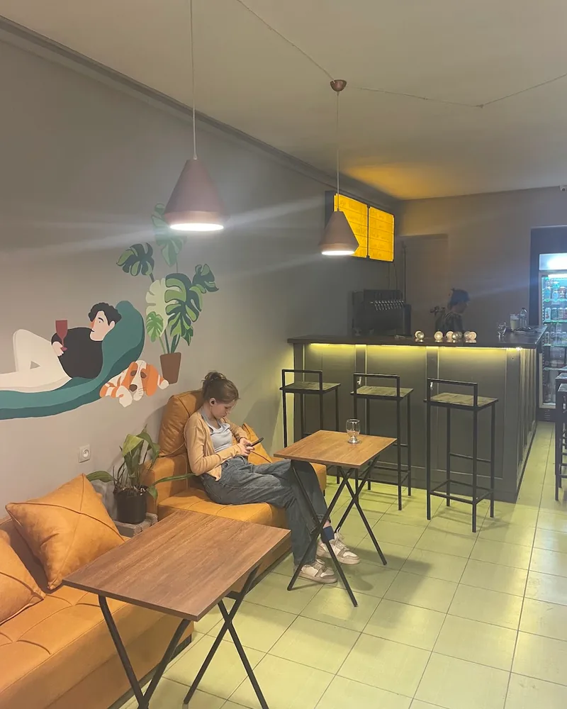 Bar seating area with yellow sofas and counter at Optimist Craft Bar