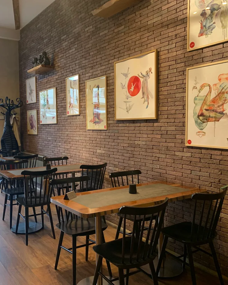 Dining area with brick wall and framed artwork at Orbeliani