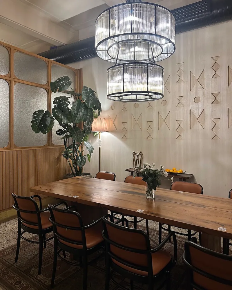 Dining table beneath tiered modern chandelier at Oro