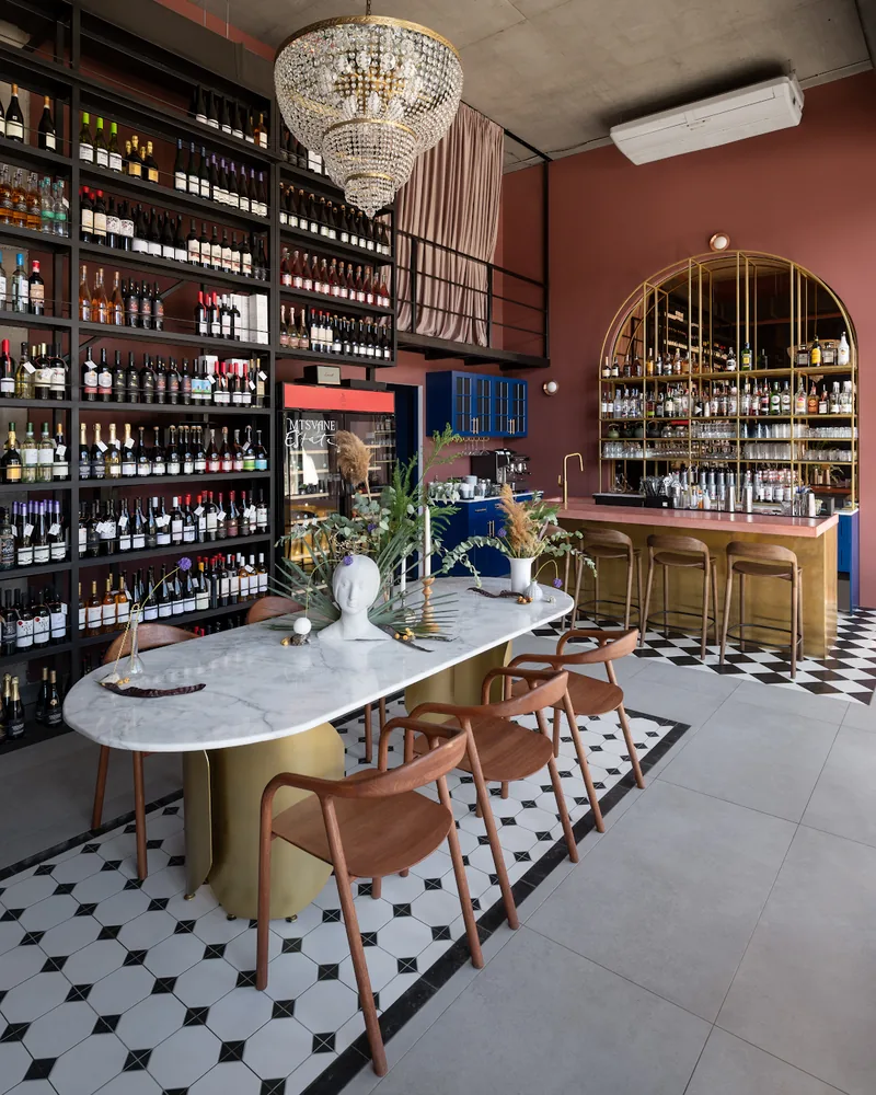 Dining space with oval marble table and wine shelves at Pasta Osteria