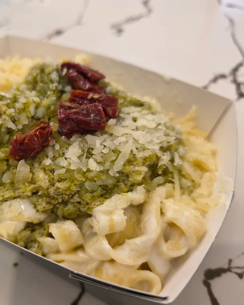 Pasta with pesto and sundried tomatoes in a paper container at Pastachi (Marjanishvili)