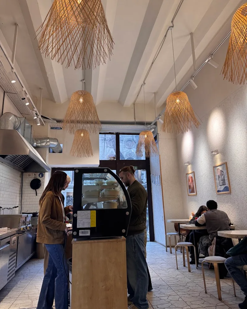 Cafe dining room with woven lampshades and counter at Pastachi (Marjanishvili)