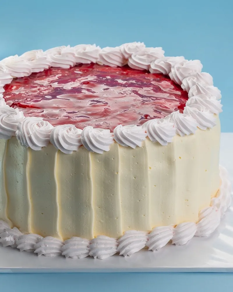 Frosted cake with a strawberry jam topping at Patisserie Bela