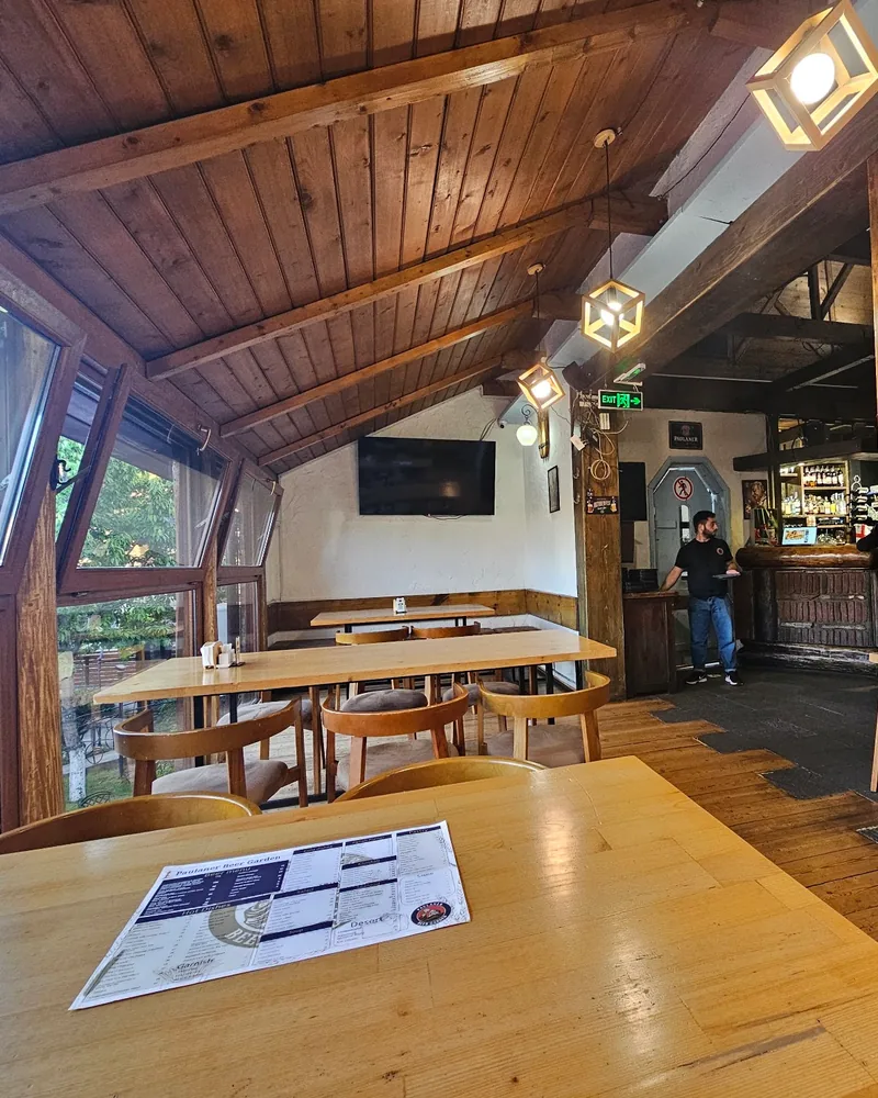 Wooden dining room with a slanted ceiling and large windows at Paulaner Beer Garden