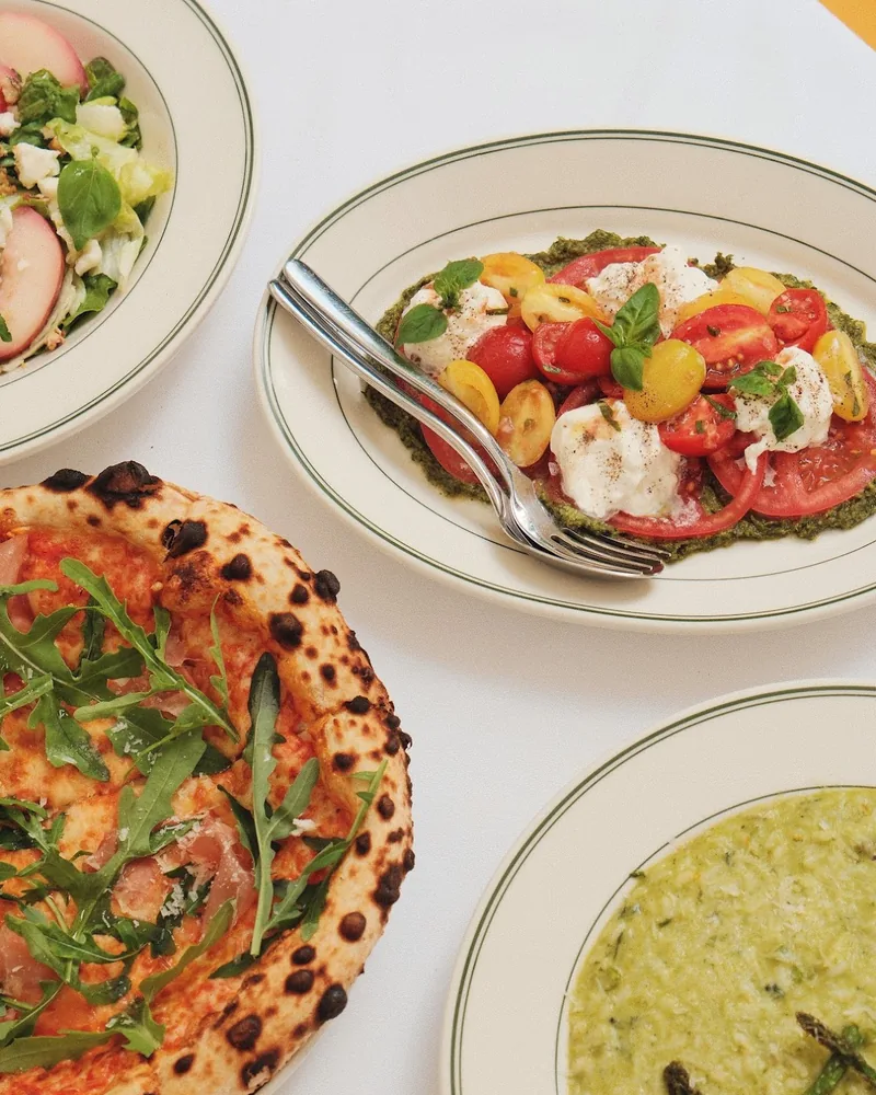Caprese salad, pizza, and risotto on a white tablecloth at Philosophico Telegraph