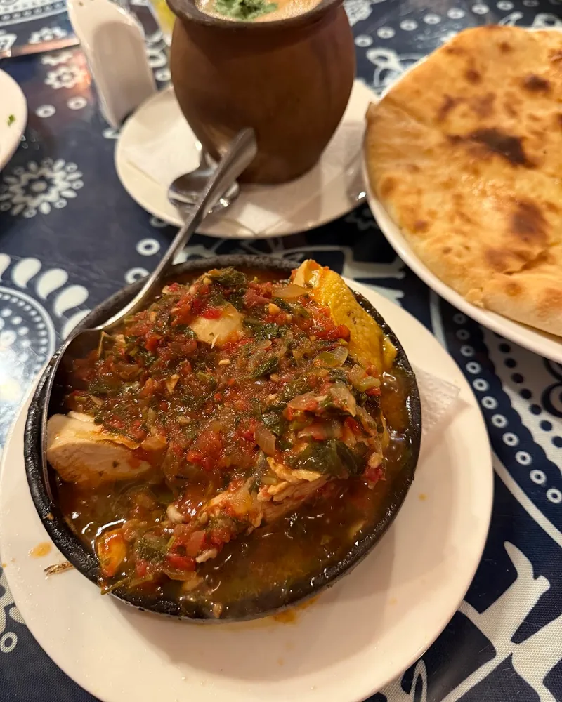 Chkmeruli or stewed meat in a ketsi clay dish with tomato herb sauce at Pirosmani's Dukani