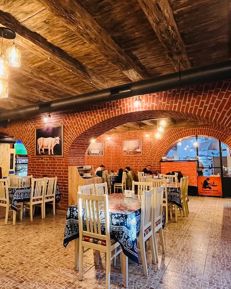 Brick-arched rustic dining room with wooden beam ceiling at Pirosmani's Dukani