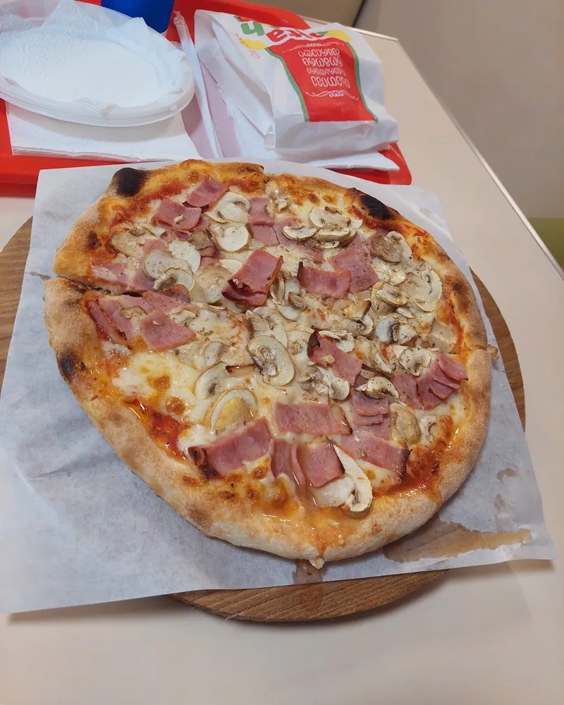 Ham and mushroom pizza on parchment paper at Pita Fresh
