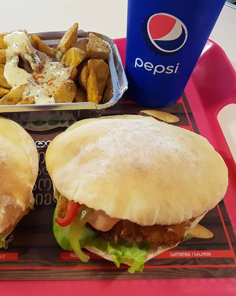 Two pita sandwiches and potato wedges on a tray at Pita Fresh