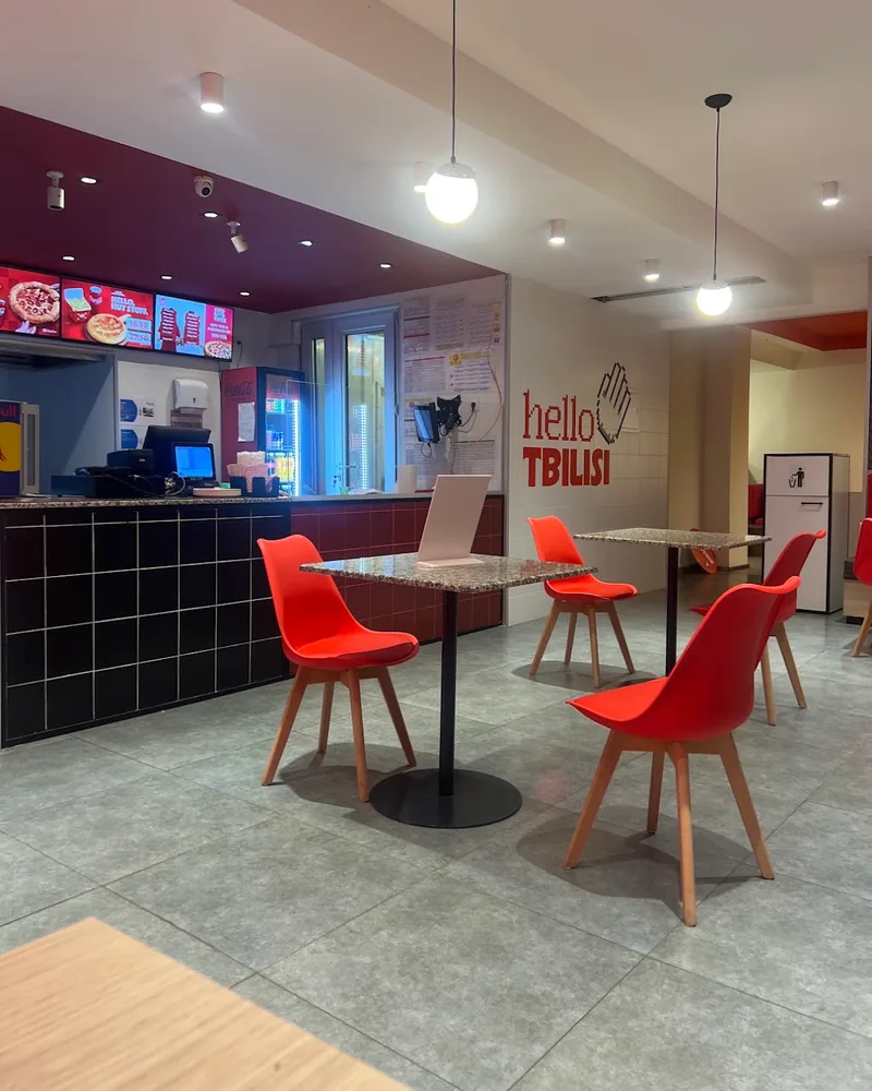 Fast food dining area with red chairs and counter at Pizza Hut (Isani)