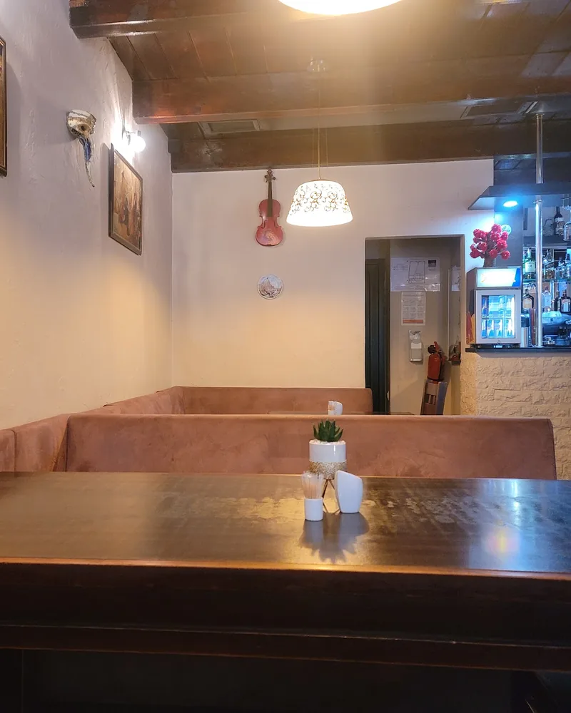 Dining area with booths and wooden table at Pizzeria Localino