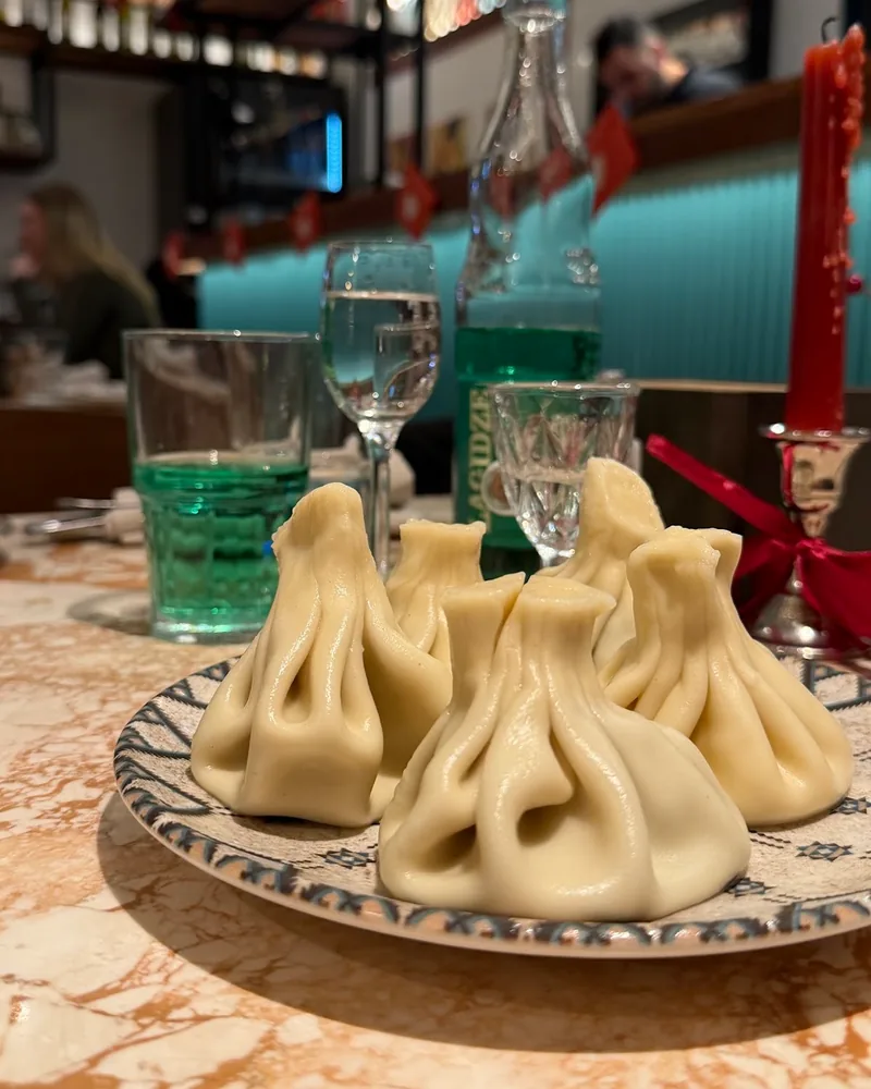 Khinkali dumplings on a patterned plate at Pkhali Khinkali