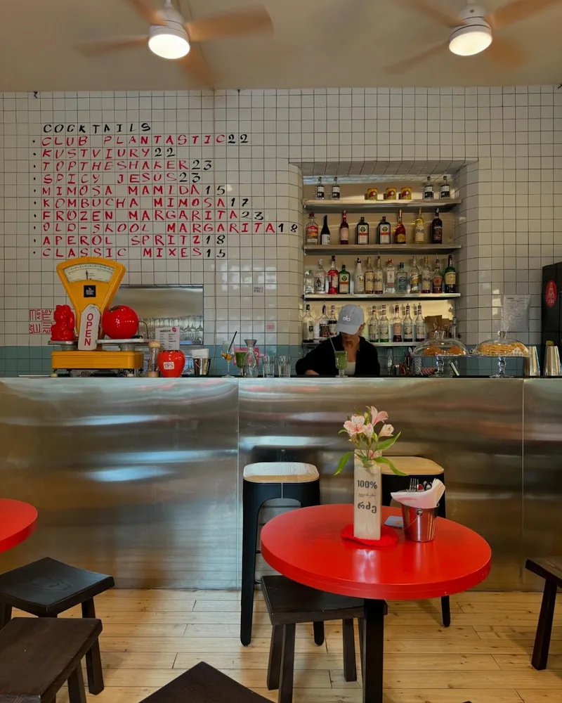 Steel bar counter under a handwritten cocktail list at Plantastic Kitchen