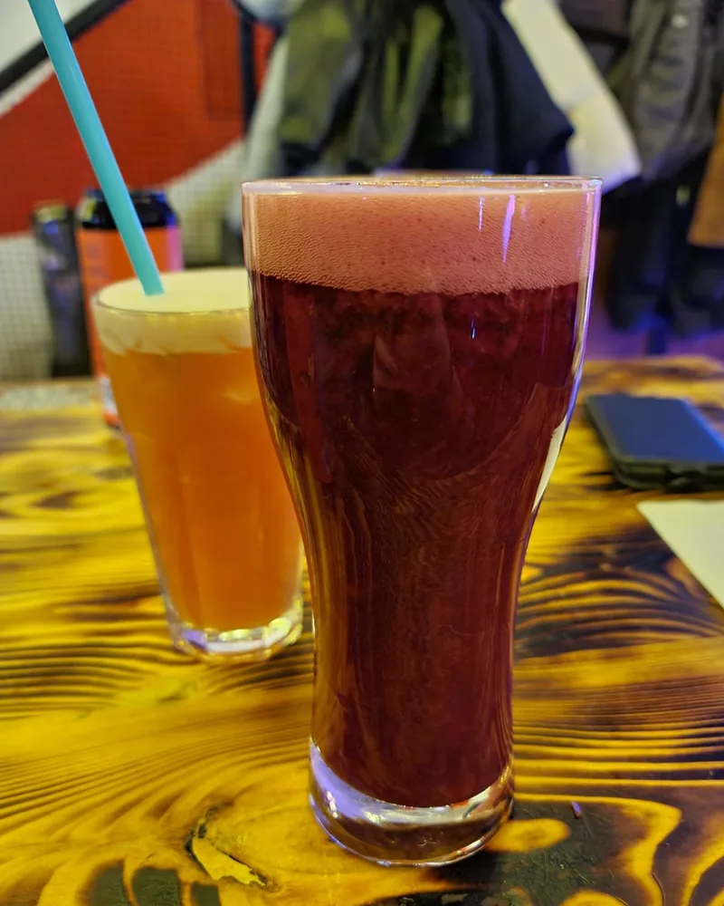 Dark red beer with foamy head in a tall glass at Poddon Bar