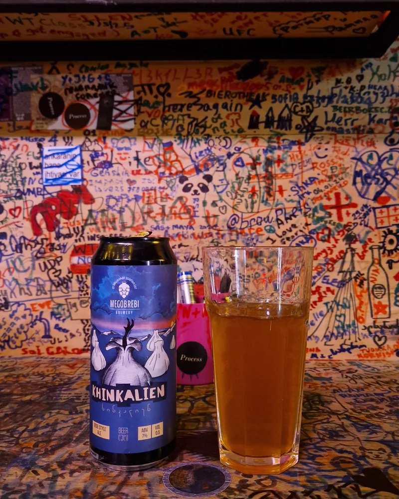 Beer can and glass of beer against graffiti wall at Process Craft Beer Bar
