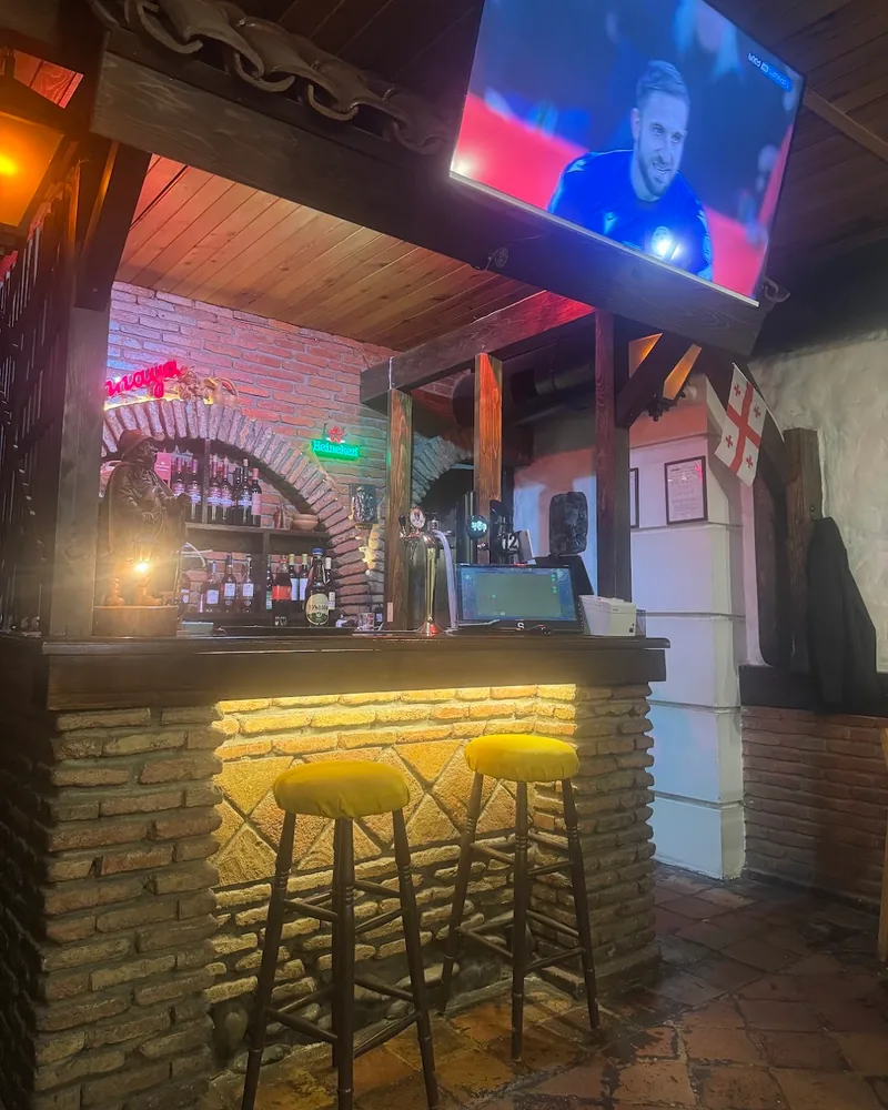 Brick bar counter with bar stools and tv screen overhead at Pub Georgian