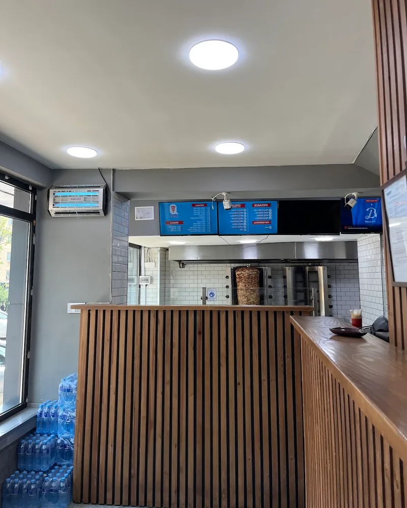 Wooden order counter and shawarma spit in kitchen at Qute's Shaurma