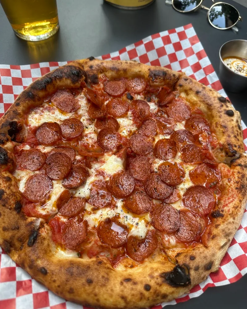 Pepperoni pizza on checkered paper at Ratto Bistro