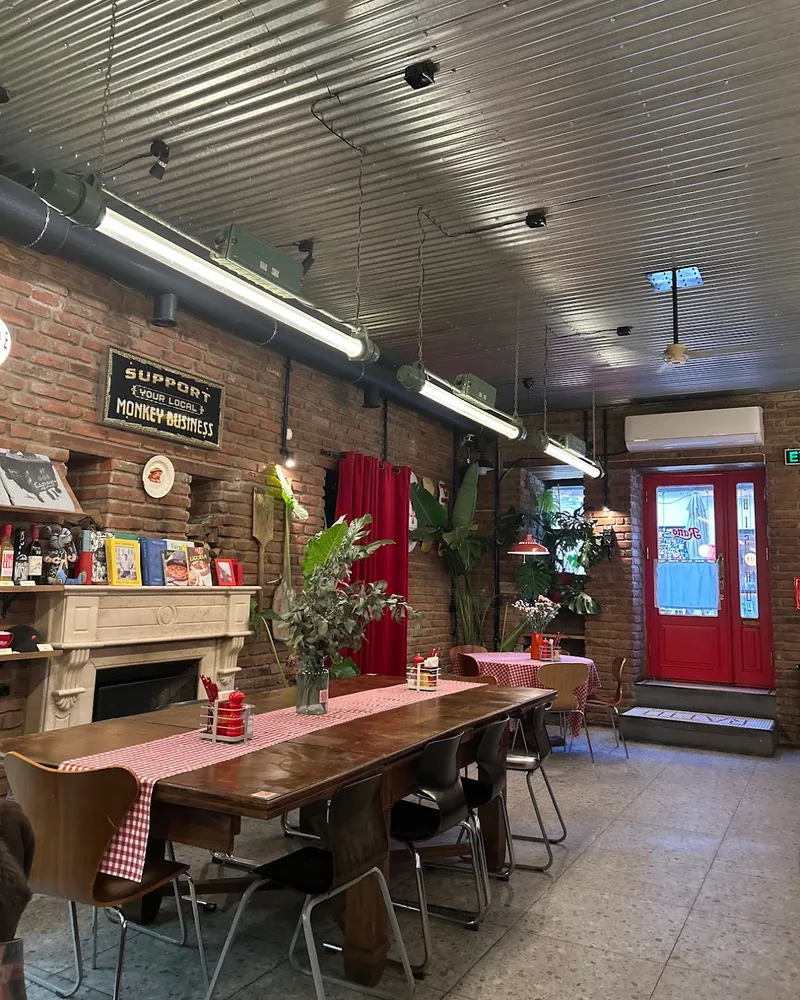 Dining room with brick walls and corrugated metal ceiling at Ratto Bistro