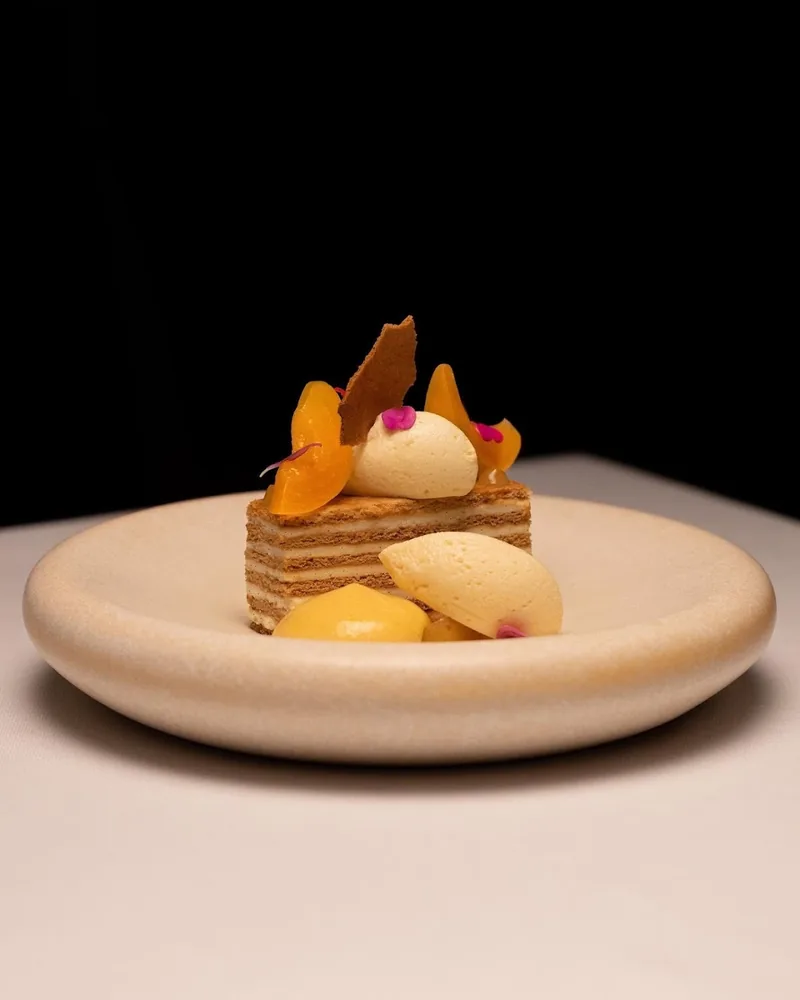 Layered honey cake dessert with sorbet and fruit at Reserve