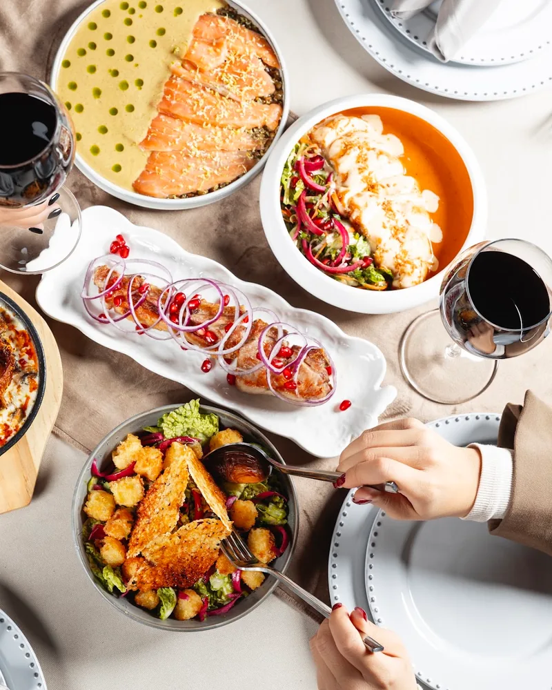 Table spread of various dishes and red wine at Chemtan