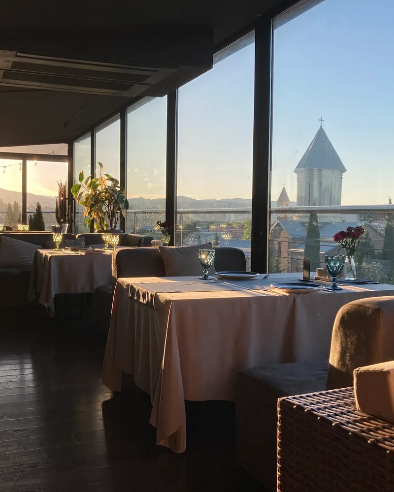 Indoor dining room with panoramic city view at golden hour at Chemtan