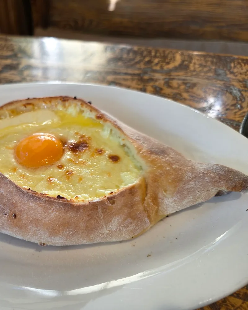 Adjarian khachapuri on an oval plate at Pasanauri (Kazbegi Avenue)