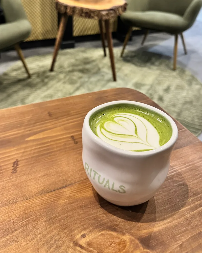 Matcha latte with latte art in a branded ceramic cup at Rituals Matcha Bar