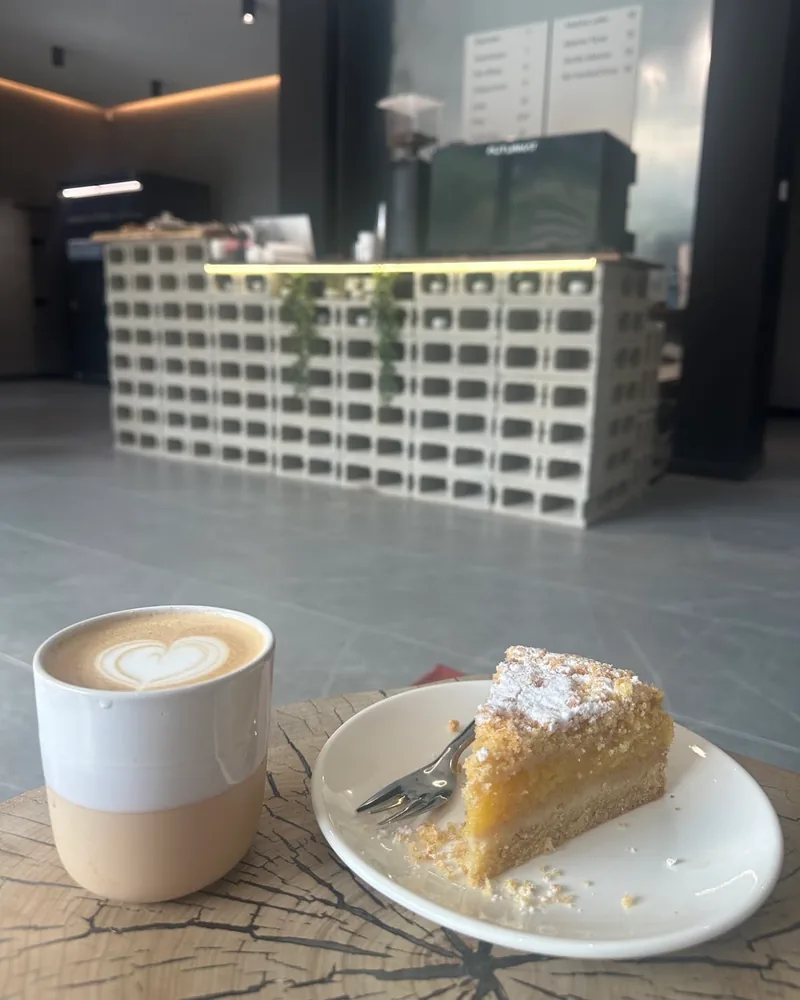 Cappuccino with latte art and slice of crumb cake at Rituals Matcha Bar