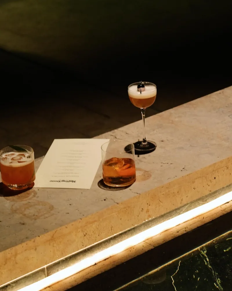 Cocktails lined up on a stone ledge at Rolling Stone Rooftop Bar