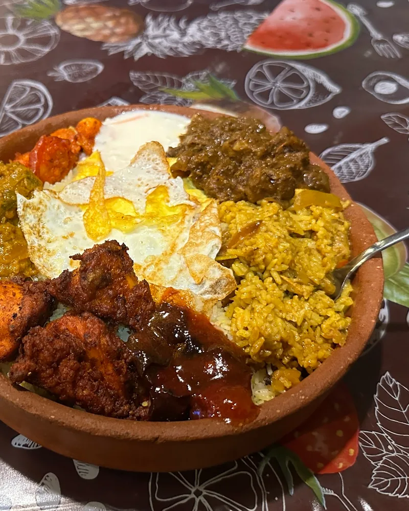 Mixed biryani platter in a clay dish with chai at Royal Kitchen Premium