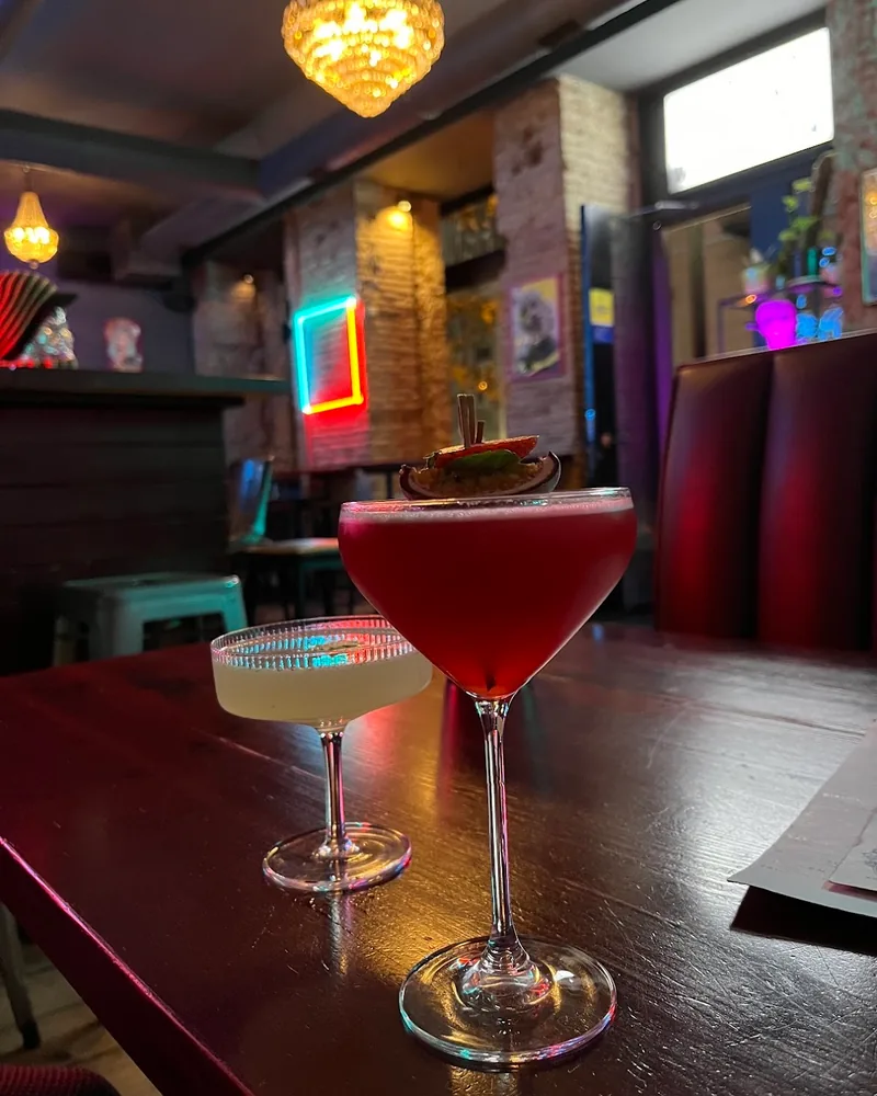Red cocktail in a coupe with a dried fruit wheel garnish at Rudeboy Bar