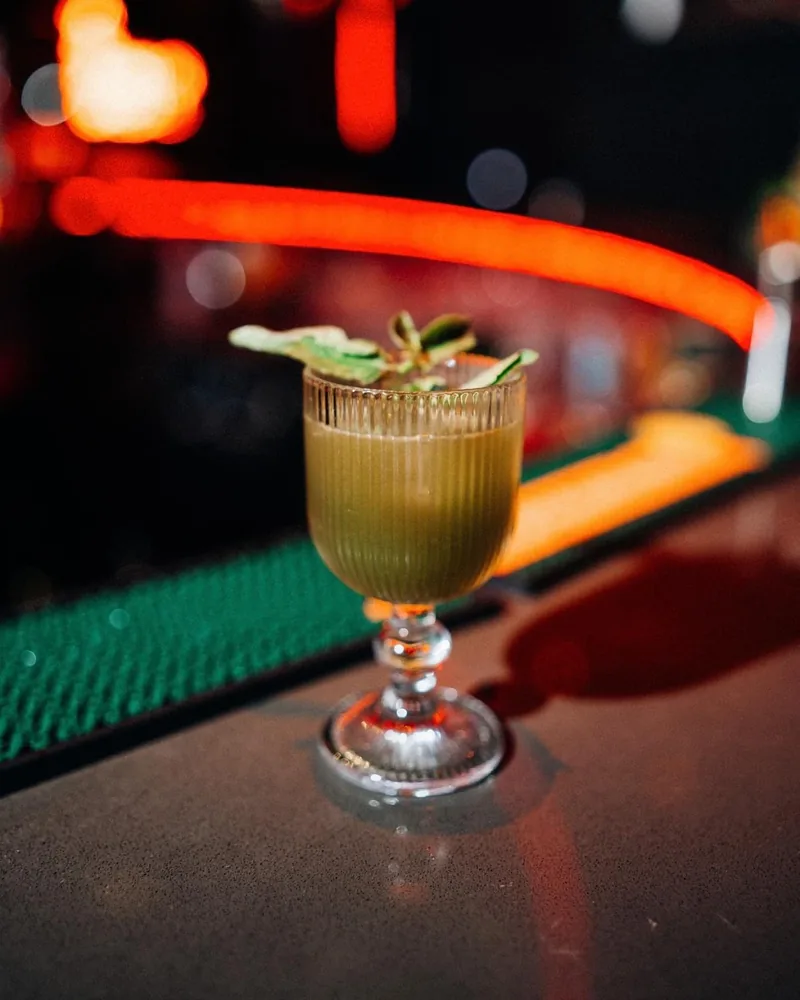 Green cocktail in a ribbed stemmed glass at Safe Night Club