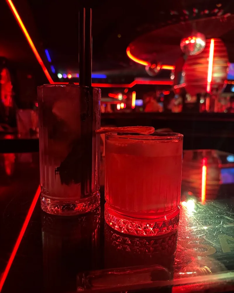 Cocktails under red neon lights at Safe Night Club