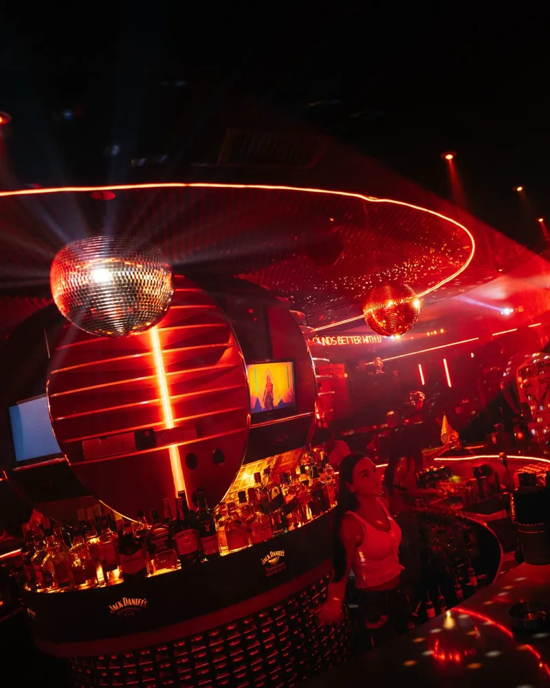 Nightclub bar with red neon lighting and disco ball at Safe Night Club