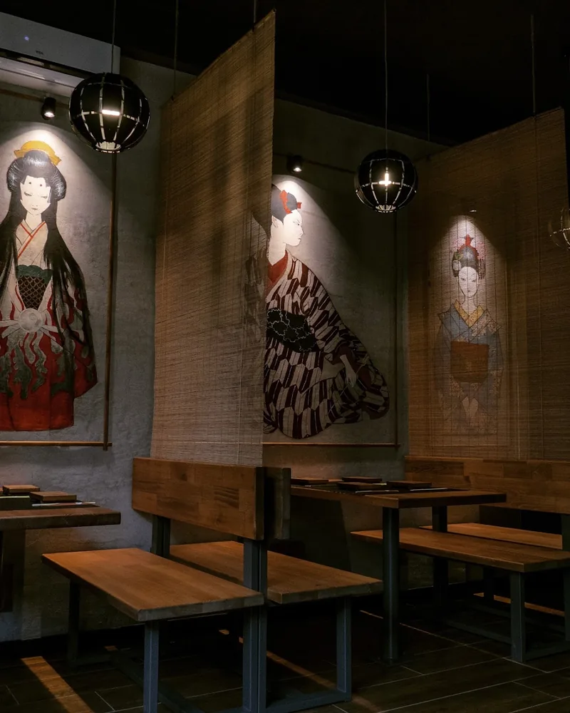 Japanese dining booths with artwork and hanging screens at Saikou Sushi Bar