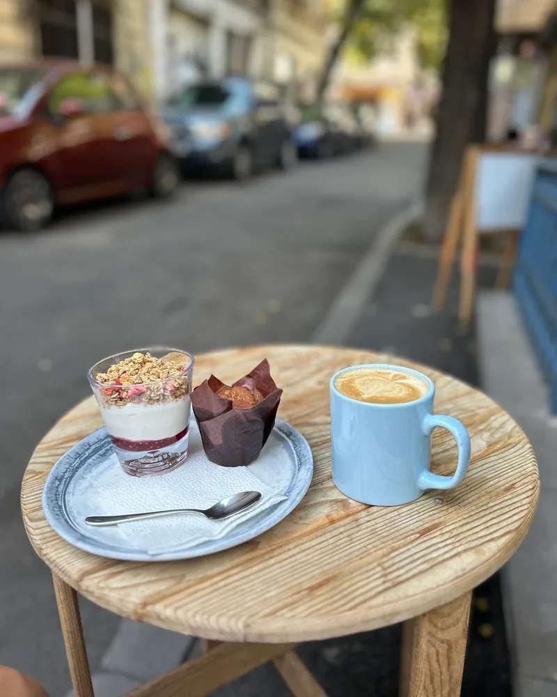 Cappuccino in a blue mug with granola and muffin at Sali Coffee