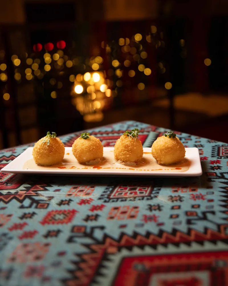 Deep-fried cheese balls on a rectangular white plate at Samsara
