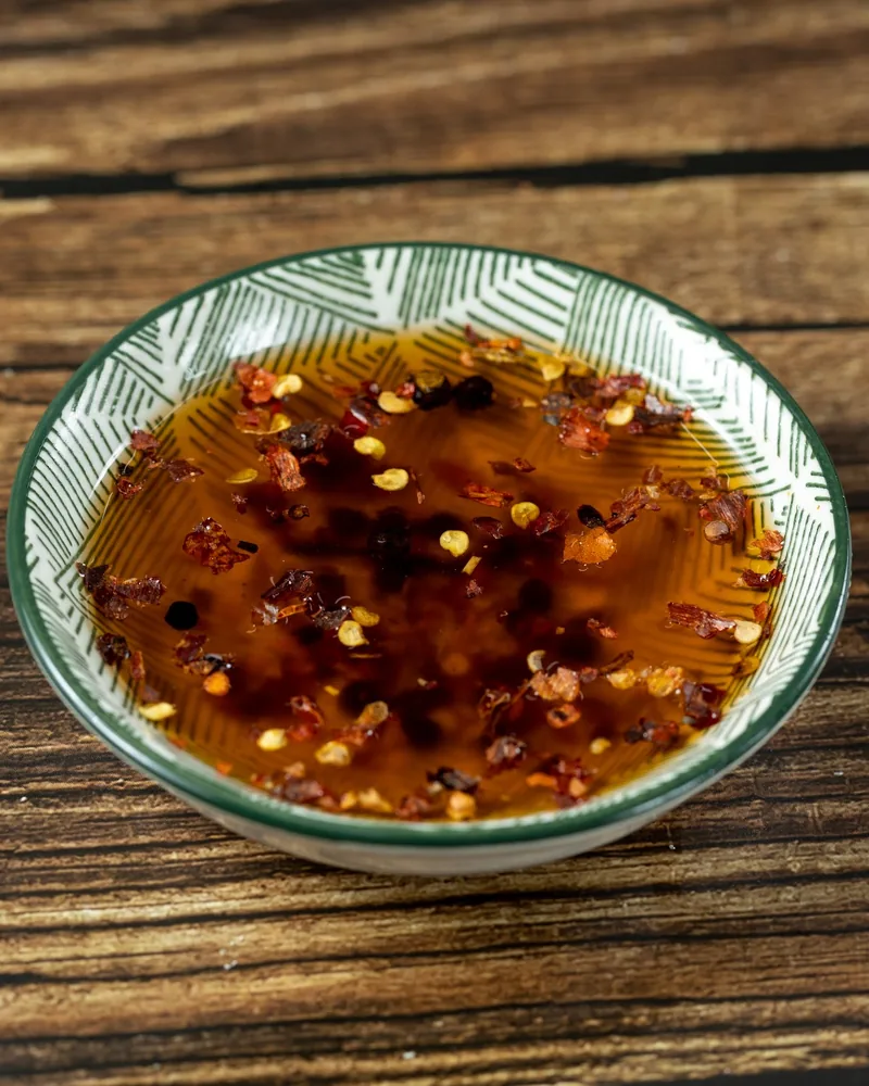 Chili oil in a small patterned ceramic bowl at Savora