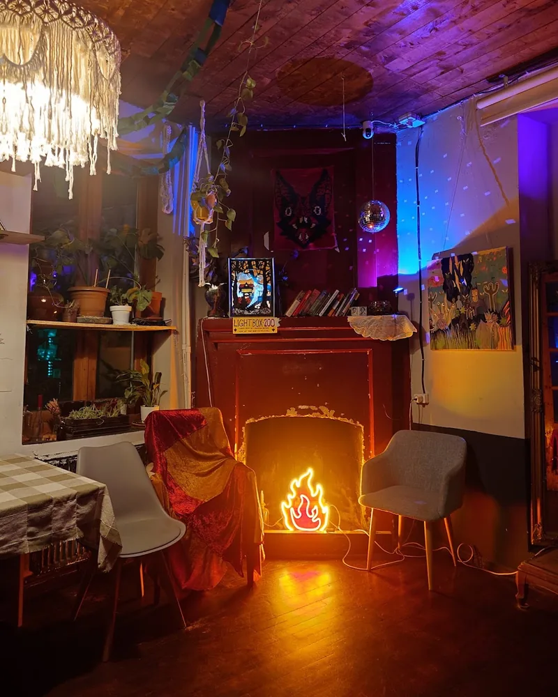 Seating area with faux fireplace and neon flame light at Secret Place