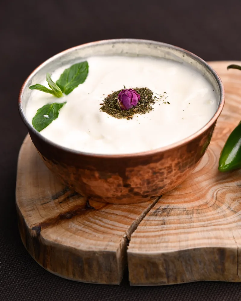 Yogurt dip in a copper bowl with mint and dried rose at Shandiz