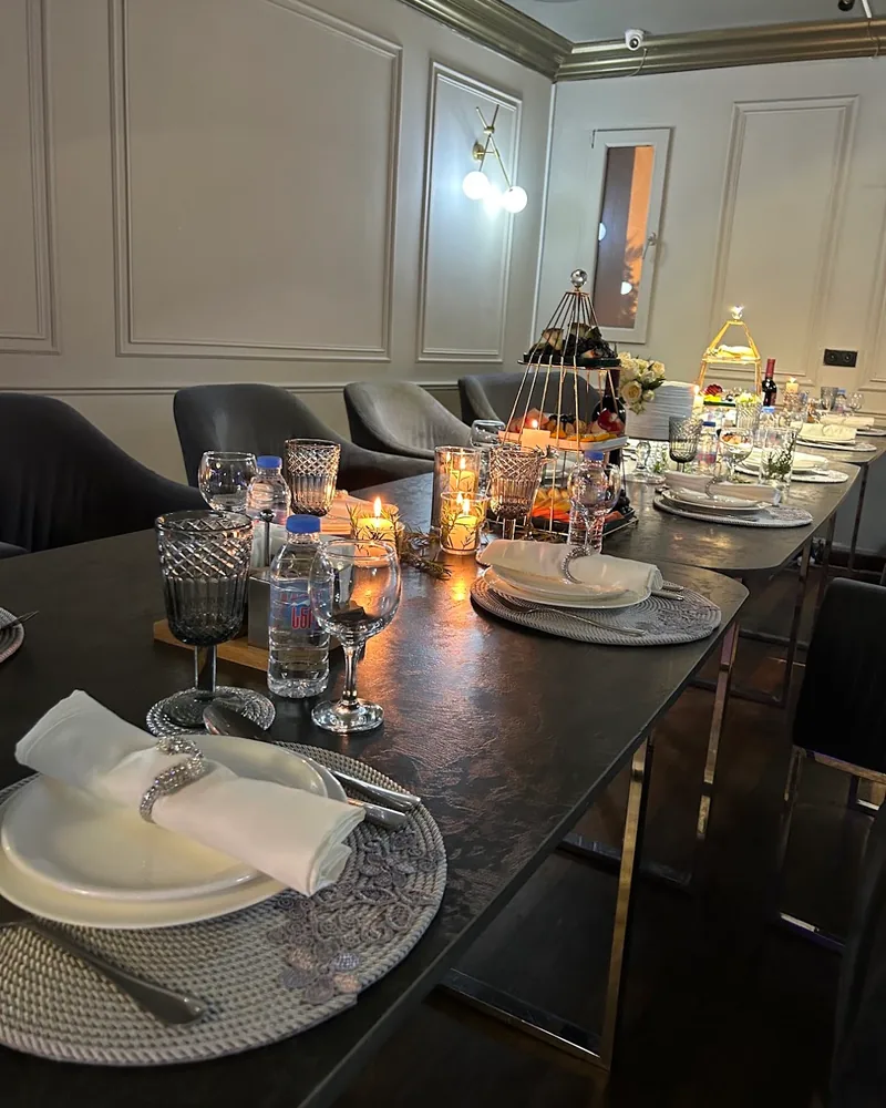 Long set dining table with candles and tiered dessert stands at Shandiz