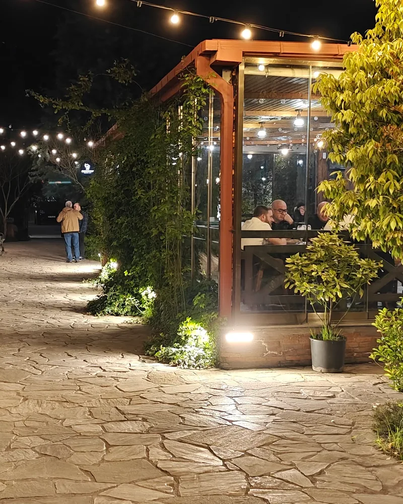 Stone paved garden walkway with outdoor dining pavilion at Sharbati