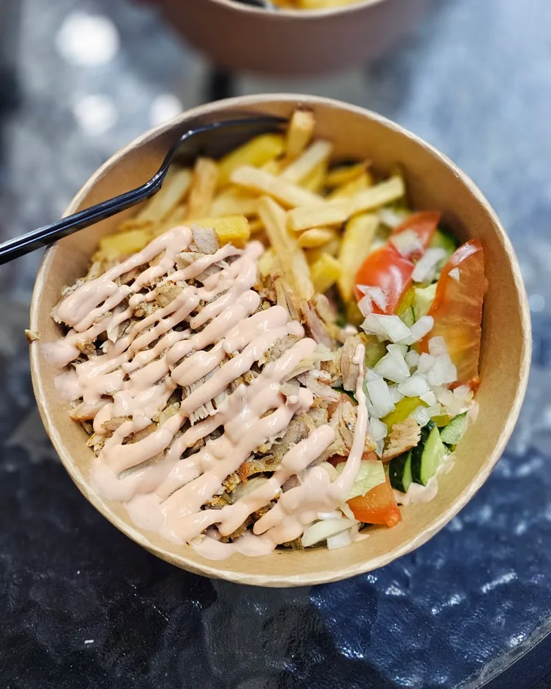 Kapsalon bowl with fries, meat, sauce, and salad at Shaurmafia