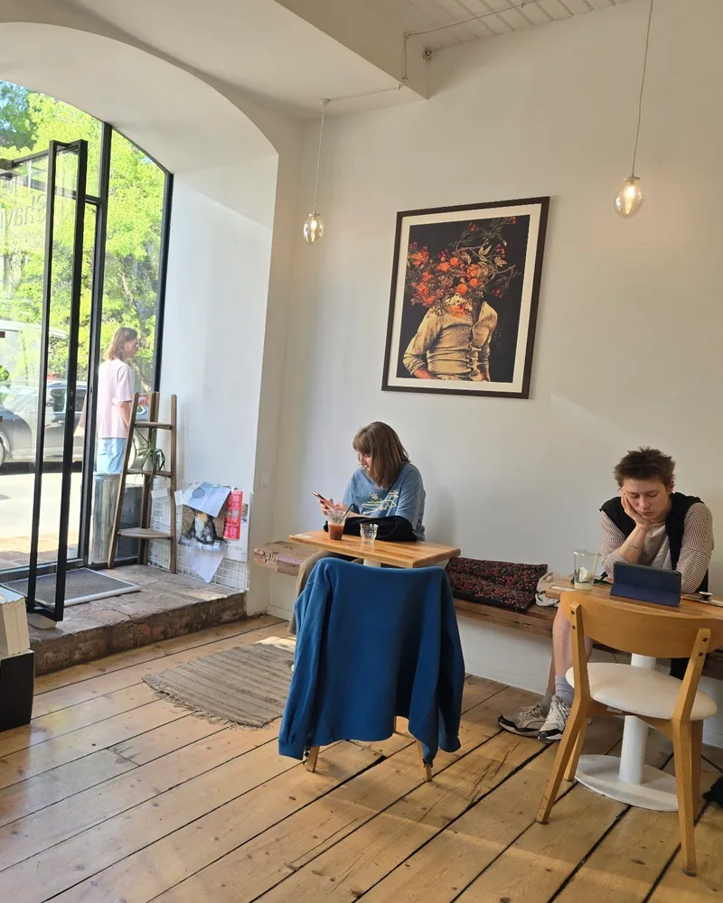 Cafe seating area with retail shelf and wooden floorboards at Shavi Coffee Roasters