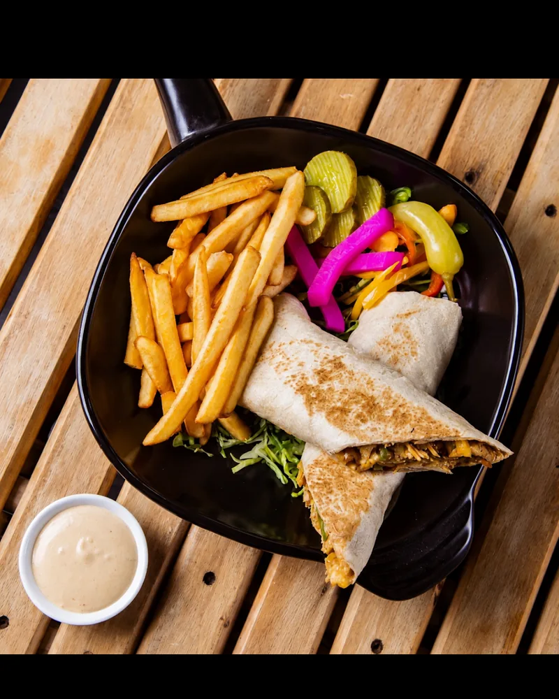 Shawarma wrap with french fries, pickles, and sauce at Shawarma Haifa