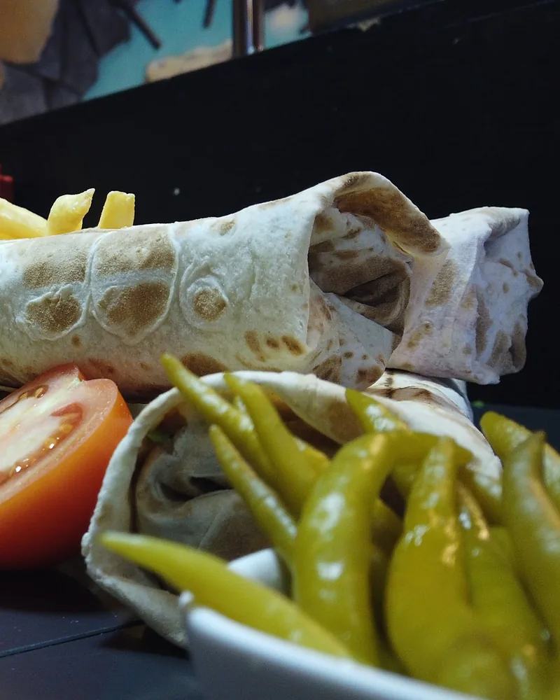 Shawarma wraps with french fries, tomato slice and pickled peppers at Shawarma Madliani
