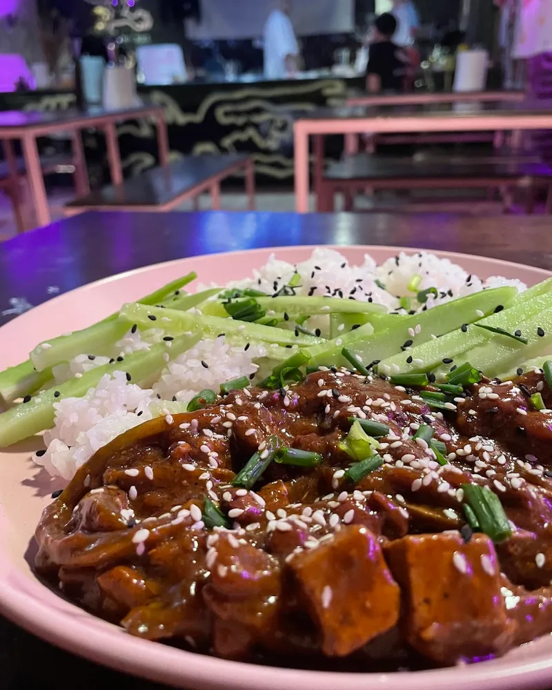 Tofu and cucumber over rice on a pink plate at Shpana