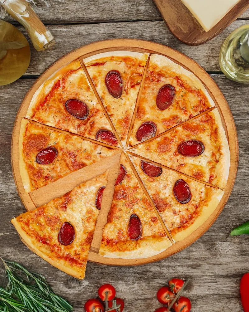 Sliced pepperoni pizza on a wooden board at Silo's Pizza & More