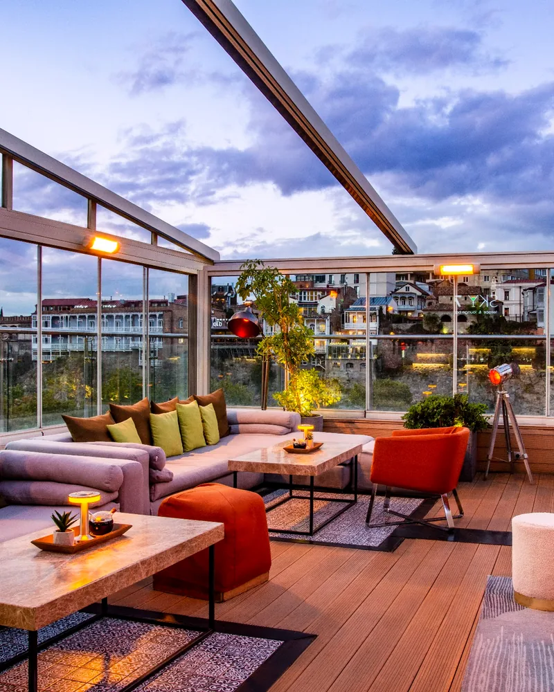 Covered rooftop terrace lounge with city views at Sky7 Terrace & Lounge Bar